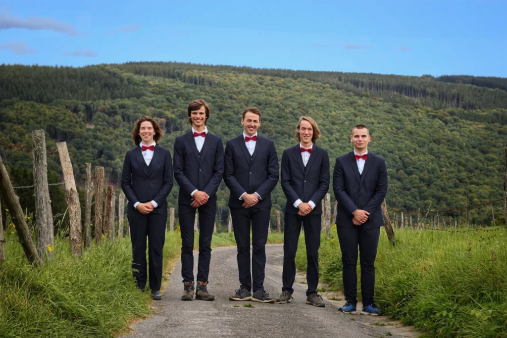 Picture of the 37th board of AEGEE-Eindhoven, pictured in front of a green field with trees on a hill in the background.